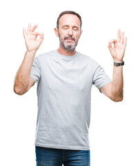 Sticker - Middle age senior hoary man over isolated background relax and smiling with eyes closed doing meditation gesture with fingers. Yoga concept.