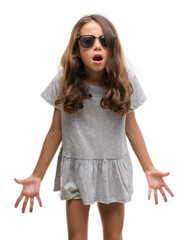 Sticker - Brunette hispanic girl wearing sunglasses afraid and shocked with surprise expression, fear and excited face.