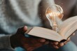 © Nld - A glowing light bulb above an open book symbolizes new ideas and inspiration