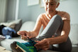 © Marko Geber - Senior woman tying shoelaces before exercise at home