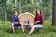 © vetal1983 - A family is relaxing at a campsite in the forest. Mother and son drink coffee near the tent.