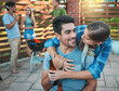 © Hira/peopleimages.com - Couple, barbeque and backyard with hug, party and labor day event with celebration and drinks outdoor. Holiday, reunion and happy people together with social group and conversation with friends