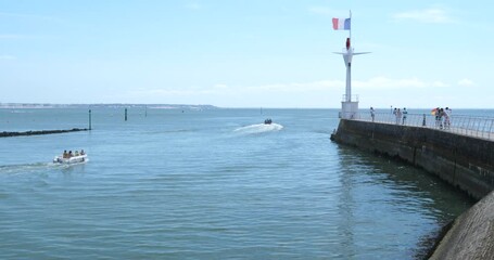 Wall Mural - Le Pouliguen, France - August 15, 2024: The port entrance with la Baule Bay and the city of la Baule in the background.