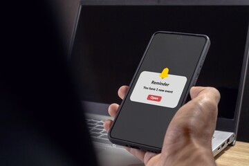 man holding a mobile phone with reminder notifications page on screen. new event notice message on m