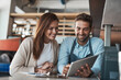 © BestLens/peopleimages.com - Tablet, couple and happy business owner in cafe for planning restaurant menu design or choice. Coffee shop, team or technology for online order, sale or check stock with barista or partner in startup
