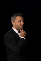 A man in a suit is standing in front of a black background