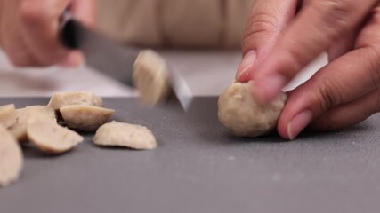 Wall Mural - Female Hand SLicing Bakso or Beef Meatballs 