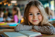 © Gonzalo - A young woman with long brown hair is smiling and holding a book. The book is open to a page with a picture on it. Concept of relaxation and enjoyment, as the woman is comfortable in her surroundings