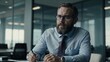 © Nailotl - A financial advisor in his 30s to 40s, with beard and glasses, works in a contemporary office. surrounded by documents with a positive attitude.