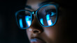 © Thawatchai - Close-Up of Computer Screen Reflection in Woman's Glasses in Dark Room