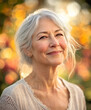 © Marco Attano - senior woman with a peaceful smile, her skin showing the natural texture of age, soft wrinkles, silver hair gently blowing in the breeze, outdoors with a blurred floral garden background
