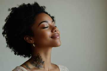 A close up of a tattooed black woman's face with her eyes closed