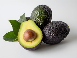 Canvas Print - Fresh avocados cut open with leaves on a white surface