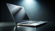 © Man888 - A sleek silver laptop computer sits alone on a dark, moody background, keyboard aglow in the dimly lit scene, evoking feelings of focused productivity.