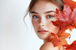 © StellaPattaya - Portrait of beautiful young woman with autumn leafs. Healthy clean fresh skin natural make up beauty eyes on white background