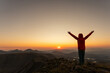© VICTOR - A person is standing on a mountain top, looking out at the sunset