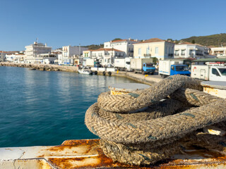 Wall Mural - Spetses island, Greece. Mooring rope closeup, blur seafront buildings