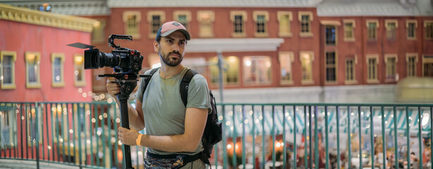 Canvas Print - Director of photography with a camera in his hands on the set. Professional videographer at work on filming a movie