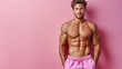 © Светлана Гуркова - Athletic man posing against a pink wall, showcasing muscular physique and casual attire