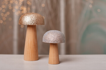 Decorative wooden mushrooms with glittering caps on a soft background. A charming addition to holiday or woodland-themed decor.