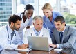 © Tekin - Businessman and group of doctors using laptop during the meeting.