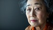© markusmiller - Middle-aged Japanese Asian woman with a serene timeless expression in a close-up portrait.