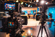 © VisualProduction - Behind scenes of television interview set: professional cameras aimed at guest speaker with host, highlighting media production and broadcast journalism.