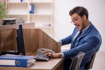 Wall Mural - Young male employee working in the office