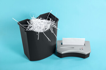 Wall Mural - Shredder, basket and paper strips on light blue background