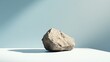 Large Rock Resting on White Surface with Light Blue Background