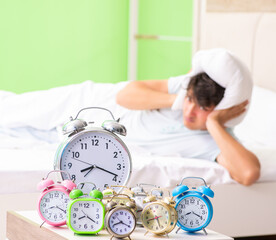 Wall Mural - Young man having trouble waking up in early morning