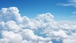 © venusvi - Puffy cumulus clouds in a bright blue sky with plenty of room for copy