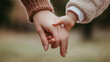 © Itsaraporn - A close-up of a mother's hand holding a child's hand with a Mother's Day bracelet