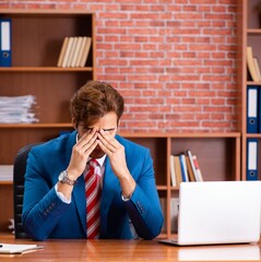 Wall Mural - Young handsome employee sitting in the office