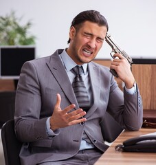 Wall Mural - Young male employee unhappy with excessive work