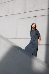 High fashion portrait of young elegant asian woman in long grey dress  outdoor.