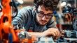 © imagemir - A man wearing safety glasses carefully works on a robotic arm in a factory setting