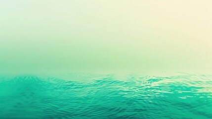 Wall Mural - A close-up view of a calm water surface, showing ripples and reflections. The water is a vibrant green color, and the sky is hazy with fog. The image captures a peaceful and tranquil morning scene.