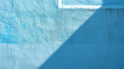 Poster - A blue concrete wall with white paint, showing signs of age and wear, is lit by the sun, casting a triangular shadow on the surface.