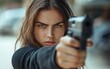 © prem - Determined woman aiming handgun: Intense focus and steady grip in action pose. Portrays self-defense, action movie concept, or firearms training for thriller book covers and personal safety campaigns.