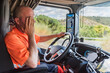© M. Perfectti - Truck driver driving the truck and rubbing his face with his hand in a clear gesture of tiredness and fatigue at the wheel.