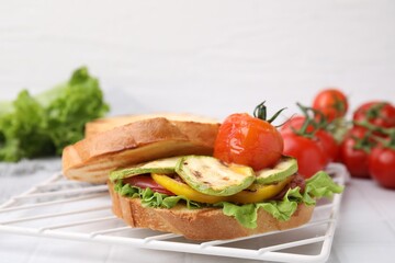 Wall Mural - Tasty sandwich with grilled vegetables on white tiled table, closeup