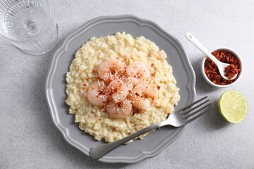 Wall Mural - Delicious risotto with shrimps and cheese served on light grey table, top view