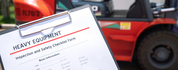 Wall Mural - a mechanical engineer is using heavy equipment checklist form for inspecting the factory forklift ve
