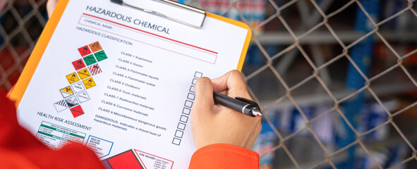 Wall Mural - extreme close-up at industrial worker'hand during verify on chemical and hazard material checklist, 