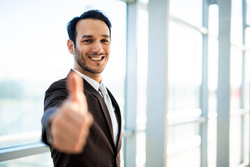 Businessman smiling showing thumbs up approving successful deal