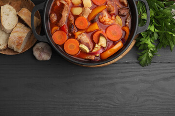 Wall Mural - Tasty homemade stew with vegetables and bread on grey wooden table, flat lay. Space for text