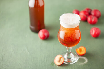 Wall Mural - Boozy Refresing Cold Hard Plum Cider or Fruit Plum Beer in a Pint Glass on wooden table. Copy space