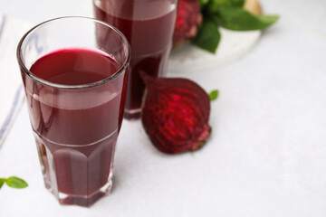 Wall Mural - Fresh beet juice in glasses on light table, closeup. Space for text