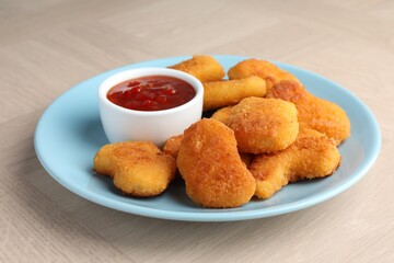 Wall Mural - Tasty chicken nuggets with chili sauce on wooden table